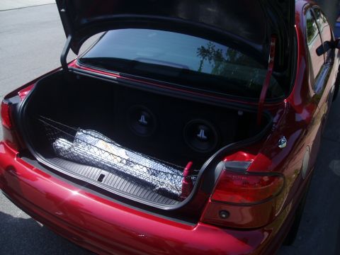 1993 Ford Taurus - Rear view of a 1993 Ford Taurus with its trunk open, revealing custom subwoofers.