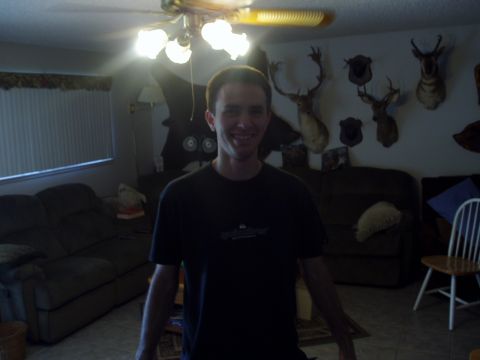 1993 Ford Taurus - Man poses in a room decorated with taxidermied deer heads and furniture.