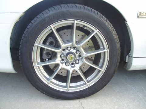 1993 Ford Taurus - Close-up of a car's wheel, showing aftermarket rims and performance brakes.
