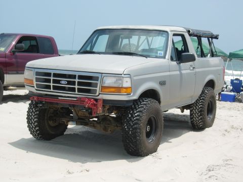 1995 Ford Bronco - Modified 1995 Ford Bronco on the beach with a red Hi-Lift jack mounted to the front.