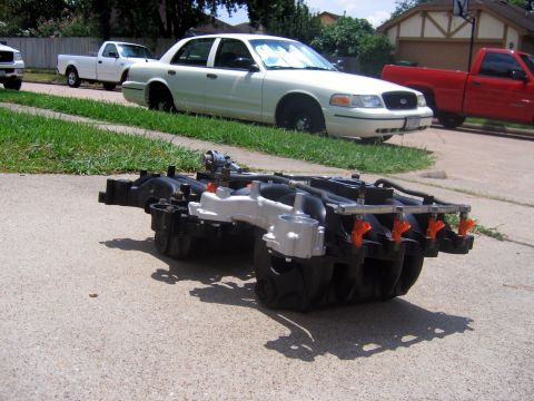 2000 Ford Crown Victoria - 2000 Ford Crown Victoria parked on street with an engine intake manifold in the foreground.