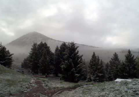 1996 Ford Bronco - Overcast sky over a snow-dusted mountain and pine trees with a rustic fence.
