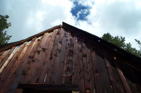 1996 Ford Bronco - The weathered wooden exterior of a structure is shown against a backdrop of clouds and blue sky.
