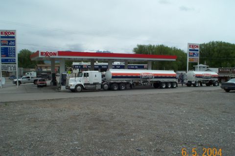 1996 Ford Bronco - Two tanker trucks are parked at an Exxon gas station, with one actively fueling.