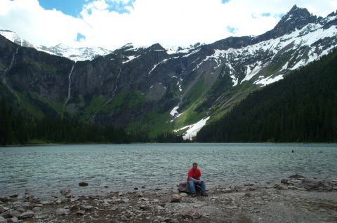 1996 Ford Bronco - A person enjoys the view of a lake and mountains, with waterfalls cascading down the slopes.