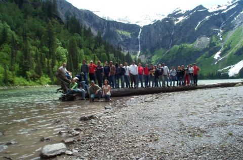 1996 Ford Bronco - A large group of people pose on a fallen tree in a scenic mountain lake setting.