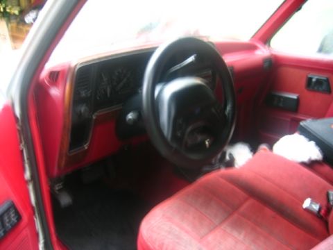 1989 Ford Bronco II - The interior of a 1989 Ford Bronco II features red upholstery and a dark dashboard.