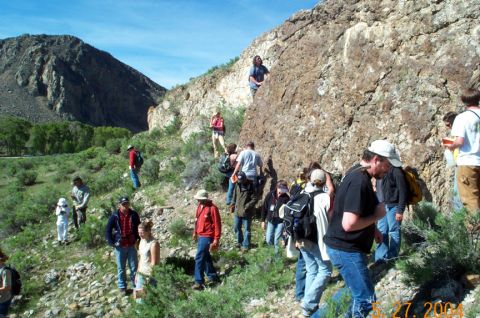 1996 Ford Bronco - People are exploring a rocky, mountainous terrain under a clear blue sky.