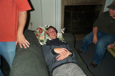 1996 Ford Bronco - Man with flowers on his head on a couch, with two friends nearby.