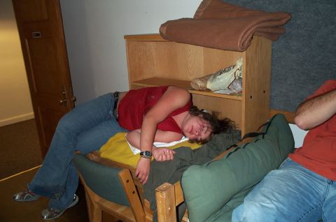 1996 Ford Bronco - A person sleeps on chairs in a room with blankets and bags on a shelf nearby.