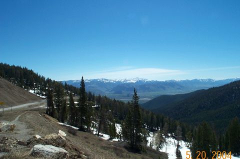 1996 Ford Bronco - A scenic view of mountains and a valley under a clear blue sky, with patches of snow on the slopes.