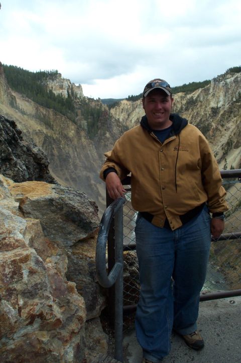 1996 Ford Bronco - A man poses for a photo on a scenic overlook with a vast canyon stretching out behind him.
