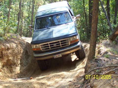 1987 Ford Bronco - This SUV navigates a challenging off-road trail, demonstrating its capability on uneven terrain.