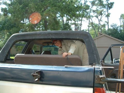 1993 Ford Bronco - A person is visible inside the rear of a Ford Bronco, looking out the window.