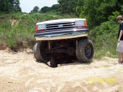 1987 Ford Bronco - 1987 Ford Bronco navigating sandy terrain with a lifted suspension.