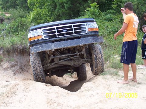 1987 Ford Bronco - Black Ford Bronco navigating a steep sandy incline during an off-road excursion.