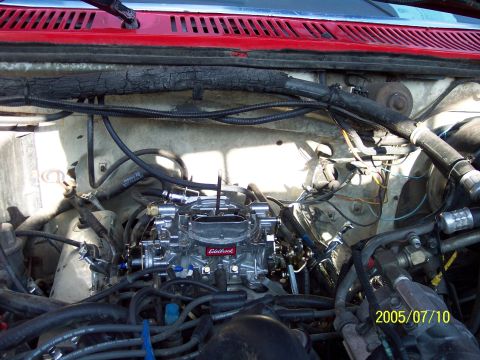 1985 Ford Bronco - Close-up of an engine bay a shiny Edelbrock carburetor and associated wiring.