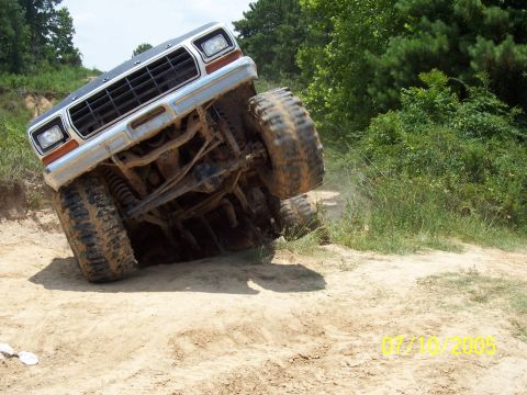 1987 Ford Bronco - A 1978 Ford Bronco navigates a steep, muddy incline off-road.