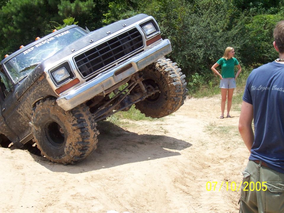 Muddy 1978 Ford Bronco tilted on its side during an off-road event