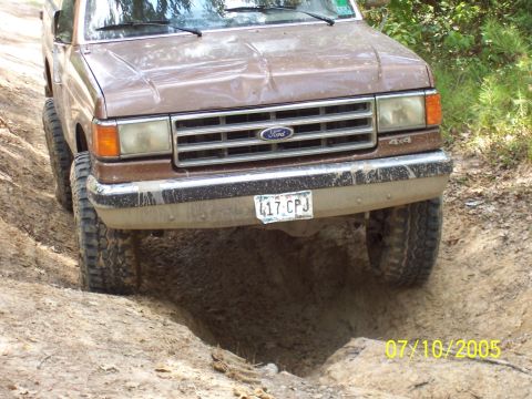1987 Ford Bronco - This Ford truck is navigating a muddy, rutted trail.