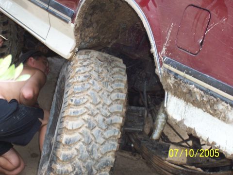1987 Ford Bronco - A person is seen working on a muddy vehicle, with another vehicle positioned closely. The date 07/10/2005 is visible.