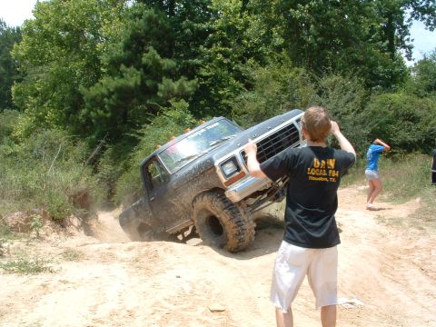 1993 Ford Bronco - A man films a black Ford truck as it maneuvers through a challenging off-road course.