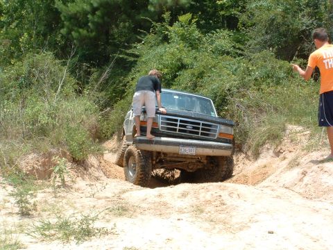 1993 Ford Bronco - Ford Bronco tackles a challenging sandy terrain with assistance from onlookers.