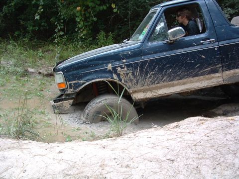 1993 Ford Bronco - This 1993 Ford Bronco is deep in the mud, with its front tire submerged.