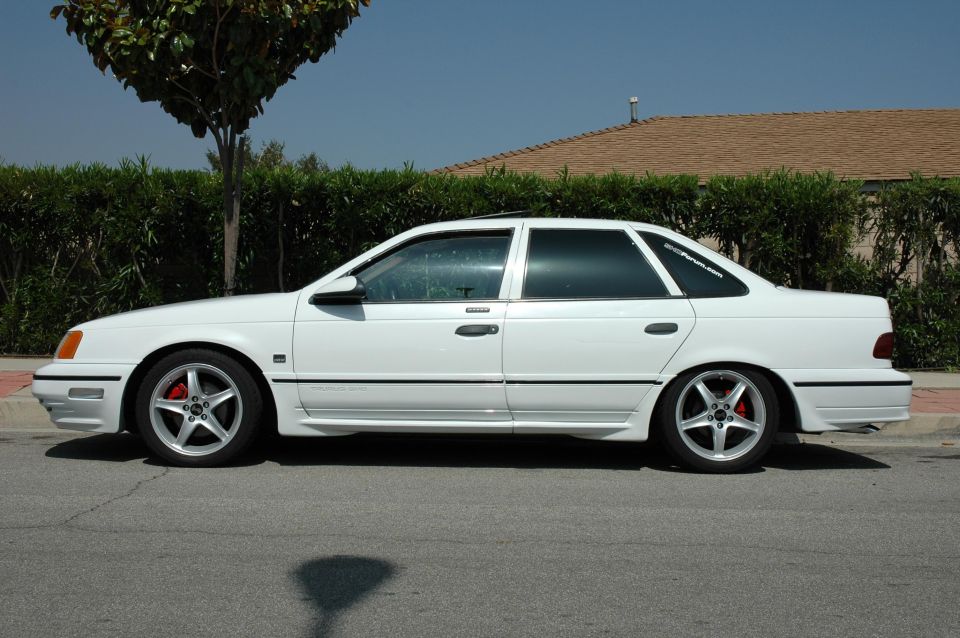 White 1993 Ford Taurus sedan parked curbside, side profile view