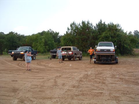 1993 Ford Bronco - Several trucks and a van on a trailer are gathered in an outdoor area.
