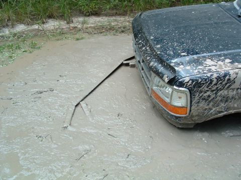 1993 Ford Bronco - This 1993 Ford Bronco is stuck in thick mud, with a tow strap visible.