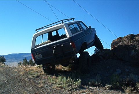 1986 Ford Bronco - This 1986 Ford Bronco navigates a challenging off-road course, demonstrating its capability on rough terrain.