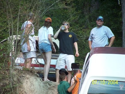 1987 Ford Bronco - Group of people standing around vehicles in an outdoor setting.