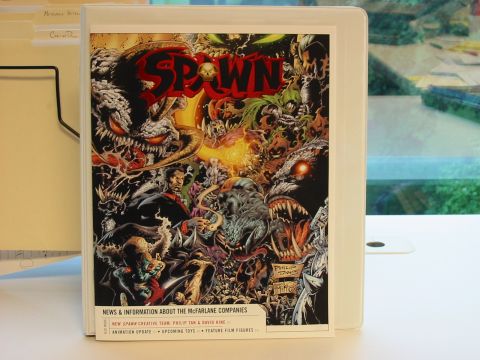 1991 Ford Bronco - A Spawn comic book cover is displayed in a binder, artwork and text about McFarlane Companies.