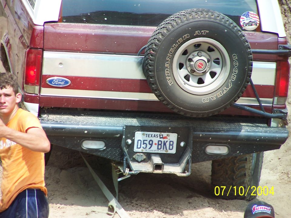 Rear view of a red 1987 Ford Bronco with a spare tire and Texas license plate
