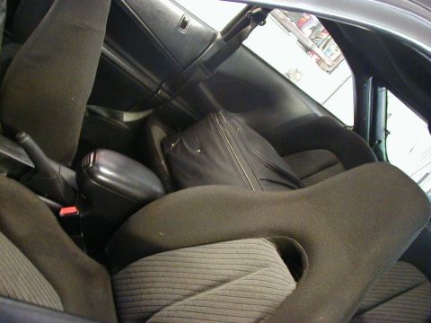 1994 Ford Probe - Interior view of a car's seats and center console, with a suitcase placed behind the seats.