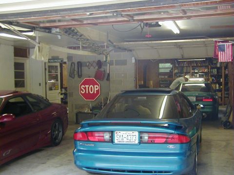 1994 Ford Probe - Two Ford Probes are parked in a garage, one teal and one red.