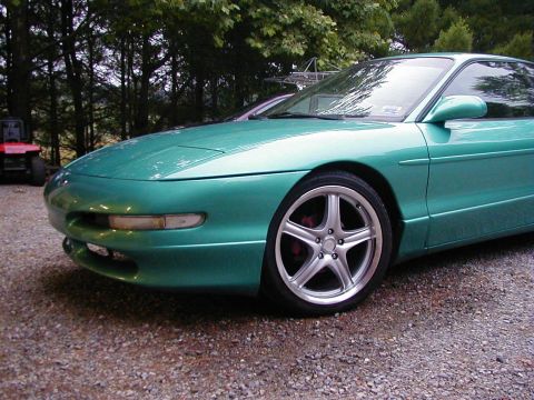 1994 Ford Probe - A teal 1994 Ford Probe is shown from the front quarter angle, aftermarket wheels.