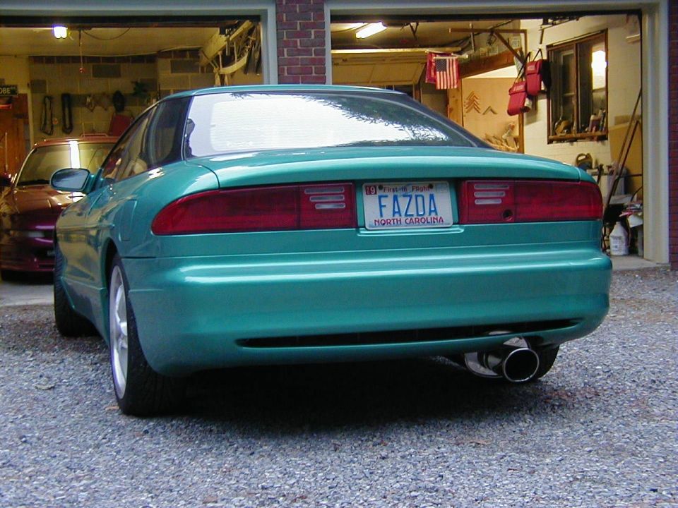 Green 1994 Ford Probe parked in a garage with another car behind it