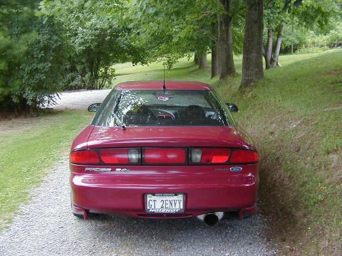 1994 Ford Probe - Rear view of a red Ford Probe GT parked on a gravel driveway with trees in the background.