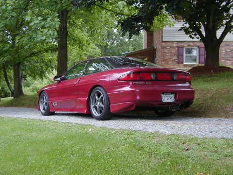 1994 Ford Probe - The rear of a red 1994 Ford Probe GT is parked on a gravel driveway.