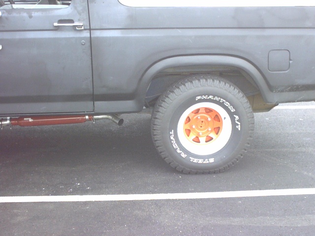 Flat-black Ford Bronco rear wheel with orange spoke rim and Phantom A/T tire