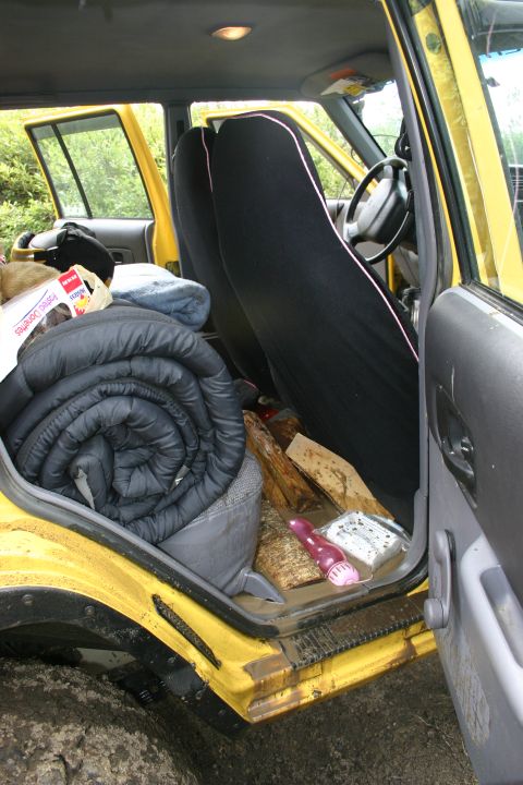 2003 Jeep TJ - Interior view of a yellow Jeep TJ loaded with camping gear and firewood, ready for an outdoor adventure.