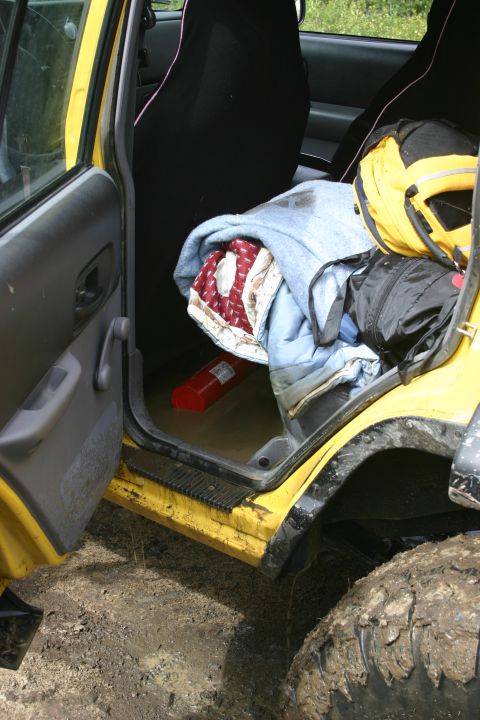 2003 Jeep TJ - Interior view of a yellow 2003 Jeep TJ, showing gear and a fire extinguisher on the floor.