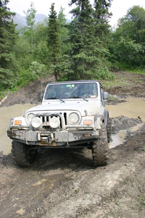 2003 Jeep TJ - Jeep TJ navigating a challenging muddy off-road path.