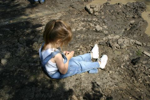 2003 Jeep TJ - A child enjoys a moment of play in a muddy outdoor environment.