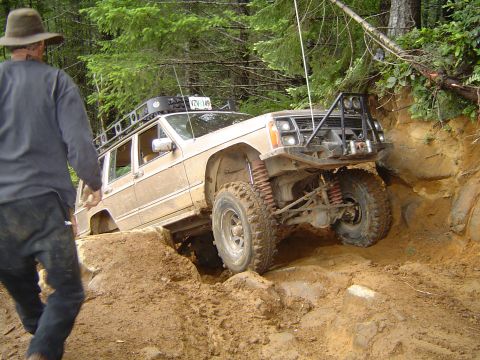 1989 Ford Bronco - A Jeep Cherokee XJ tackles a challenging off-road course, demonstrating its capability on rough terrain.