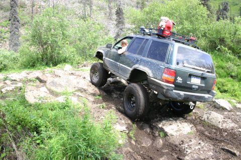 2003 Jeep TJ - Modified Jeep Grand Cherokee tackling a challenging off-road course with steep inclines and large rocks.