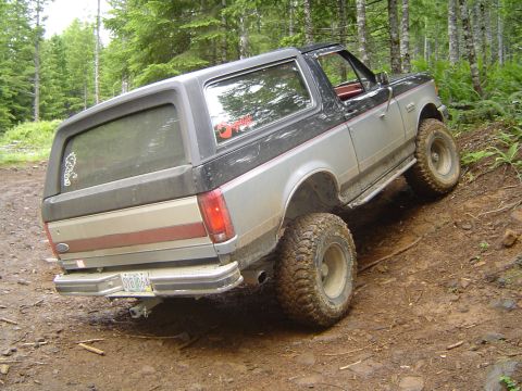 1989 Ford Bronco - This modified Ford Bronco navigates a muddy, wooded path.