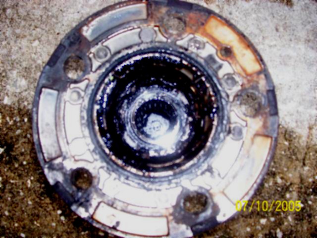 Greasy front locking hub assembly with exposed splined center, lying on concrete, dated 07/10/2005